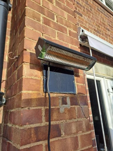 Outside electric heater attached to a brick wall